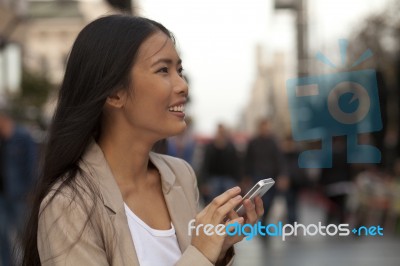 Young Woman Using A Phone Outside  Of Office Stock Photo