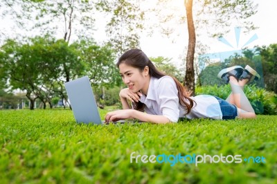 Young Woman Using Laptop In Park Stock Photo