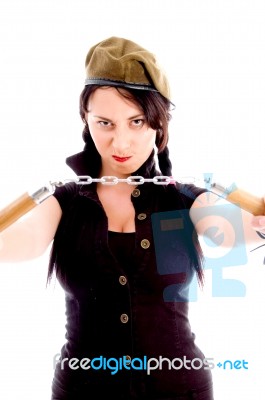 Young Woman Wearing Army Cap And Holding Nunchaku In Anger Stock Photo