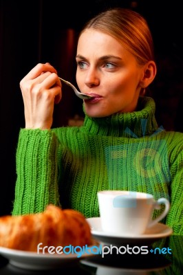 Young Woman With A Spoon In Her Mouth Making Breakfast With A Cu… Stock Photo