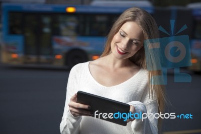 Young Woman With A Tablet On The Street Stock Photo