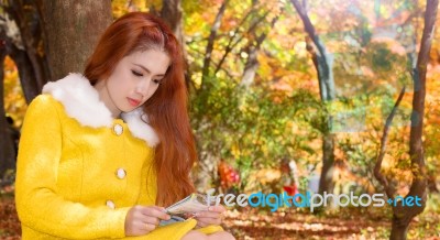 Young Woman With Autumn Leaves In Maple Garden Stock Photo