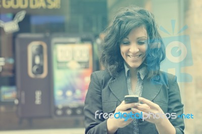 Young Woman With Cell Phone Walking Stock Photo