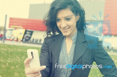 Young Woman With Cell Phone Walking Stock Photo