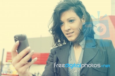 Young Woman With Cell Phone Walking, Blured Business Building In… Stock Photo