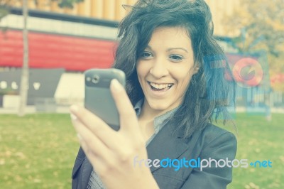 Young Woman With Funny Hair Smile Using Cell Phone Walking Stock Photo