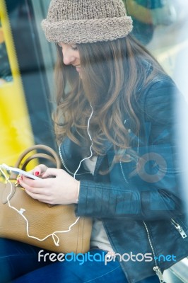 Young Woman With Her Mobile Phone While Waiting For The City Bus… Stock Photo