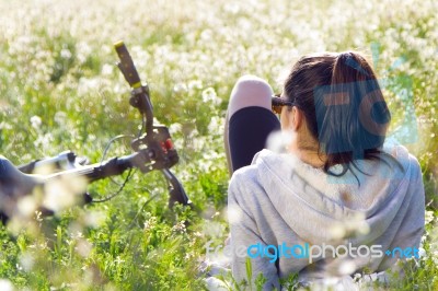 Young Woman With Mountain Bike Stretched On The Field Stock Photo