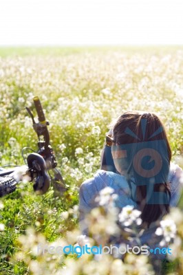 Young Woman With Mountain Bike Stretched On The Field Stock Photo