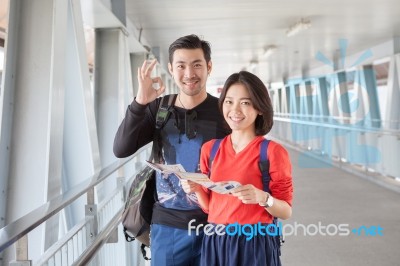 Younger Asian Traveling Man And Woman Standing With Toothy Smiling Face Sigh All Right By Okay Hand Sue For Modern People Backpacker Traveling Lifestyle Stock Photo