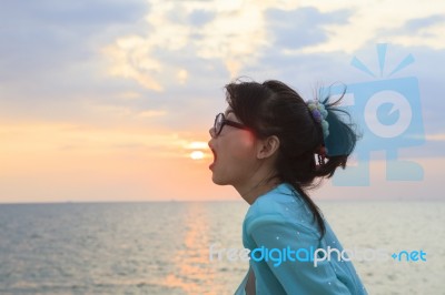 Younger Asian Woman Open Mouth With Sun Set Sky Background Stock Photo