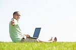 A Young Men Sit On The In The Park Using A Laptop Stock Photo