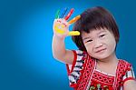 Adorable Little Asian (thai) Girl Painting Her Palm, On Blue Bac Stock Photo