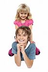 Adorable Sister Sitting On Her Brothers Back Stock Photo