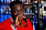 African Guy Drinking Beer, Blur Background Stock Photo