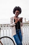 African Woman With Her Smartphone Listening Music Stock Photo