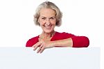 Aged Woman Standing Behind Blank Billboard Stock Photo