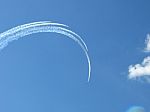 Aircrafts Drawing White Smoke Circles Into The Blue Sky Stock Photo