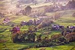 Alpine Village In Mountains. Smoke And Haze Over Hills Stock Photo