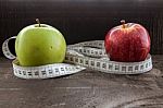 An Apple Surrounded By A Measuring Tape Tailor On Wood Stock Photo