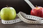 An Apple Surrounded By A Measuring Tape Tailor On Wood Stock Photo