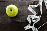 An Apple Surrounded By A Measuring Tape Tailor On Wood Stock Photo