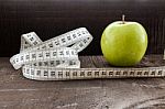 An Apple Surrounded By A Measuring Tape Tailor On Wood Stock Photo