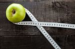 An Apple Surrounded By A Measuring Tape Tailor On Wood Stock Photo