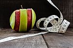 An Apple Surrounded By A Measuring Tape Tailor On Wood Stock Photo