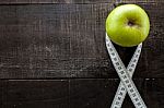 An Apple Surrounded By A Measuring Tape Tailor On Wood Stock Photo