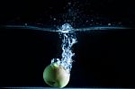 Apple Thrown Into The Water Stock Photo