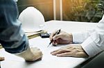 Architects Engineer Discussing At The Table With Blueprint - Clo Stock Photo