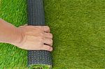 Artificial Turf Green Grass Roll With Hand Stock Photo