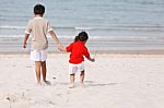 Asian Boys Holding Hands On Beach Stock Photo