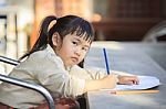 Asian Children With Yellow Pencil In Hand Doing School Home Work With Happiness Emotion Stock Photo