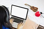 Asian Girl Sitting On Bed Surfing Internet Or Working On Noteboo Stock Photo