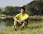 Asian Man Sitting  In The Park Stock Photo