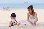 Asian Mom And Son Playing On Beach Stock Photo