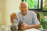 Asian Senior Man With Vintage Coffee Grinder Stock Photo