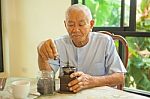 Asian Senior Man With Vintage Coffee Grinder Stock Photo