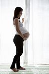 Asian Woman Pregnant ,pregnancy Standing In Home Room Against Wh Stock Photo