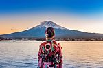 Asian Woman Wearing Japanese Traditional Kimono At Fuji Mountain. Sunset At Kawaguchiko Lake In Japan Stock Photo