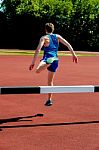 Athlete Jumping Over The Hurdle Stock Photo