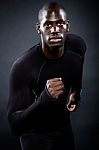 Athletic Man Running In Black Background Stock Photo