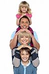 Attractive Smiling Family Of Four Posing In A Single Line Stock Photo