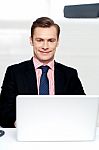 Attractive Smiling Man Operating A Laptop Stock Photo