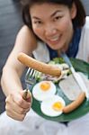 Attractive Woman Giving A Sausage Stock Photo