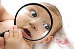 Baby Holding Magnified Glass Stock Photo