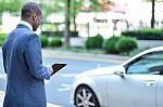 Back View Of African Man Holding Tablet Stock Photo