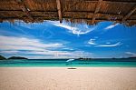 Beach Umbrella With Emerald Sea On A Sunny Day, Island In Background, Thailand Stock Photo